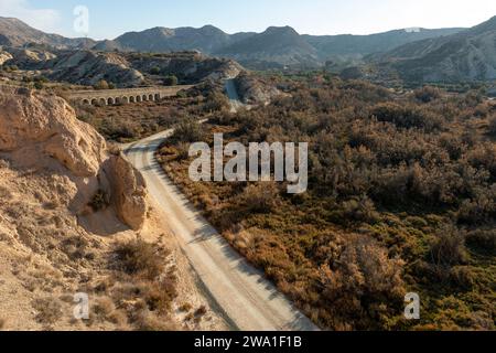 Feldweg in trockener Wüstenlandschaft mit fernen Klippen und Morgensonnenlicht, Elche, Provinz Alicante, Spanien – Stockfoto Stockfoto