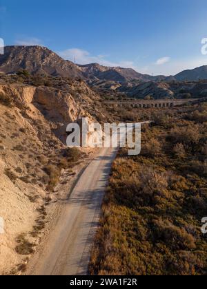 Feldweg in trockener Wüstenlandschaft mit fernen Klippen und Morgensonnenlicht, Elche, Provinz Alicante, Spanien – Stockfoto Stockfoto