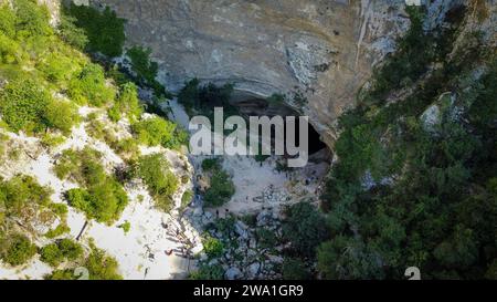 Großes Loch im Berg von einer Drohne aus gesehen. Wiedererstarkung des Flusses Sorgue in der Provence, Fontaine de Vaucluse. Ist die tiefste Wasserquelle Europas Stockfoto