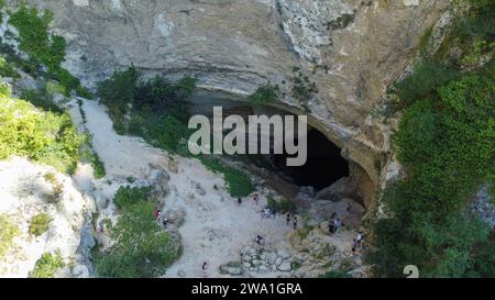 Großes Loch im Berg von einer Drohne aus gesehen. Wiedererstarkung des Flusses Sorgue in der Provence, Fontaine de Vaucluse. Ist die tiefste Wasserquelle Europas Stockfoto