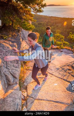 Junges Paar klettert im Herbst auf Beehive im Acadia-Nationalpark, Maine, USA Stockfoto