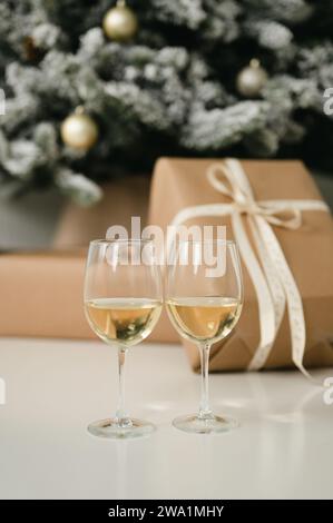 Zwei Weingläser vor einem weihnachtsbaum mit Geschenken Stockfoto