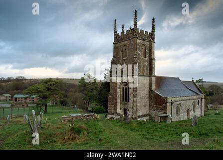 Das „verlorene Dorf“ von Imber, Salisbury Plain, Wiltshire, Großbritannien, zeigt die Kirche, Imber Court (grüne Fensterläden) und die Armee-Trainingshäuser und Warnschild. Stockfoto