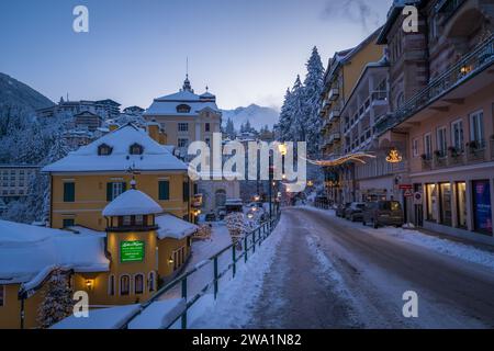 Blaue Stunde im verschneiten österreichischen Dorf mit Bergen in der Ferne Stockfoto