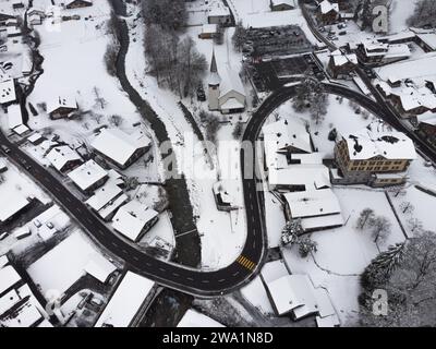 Aus der Vogelperspektive auf die schneebedeckte schweizer Stadt mit dem Fluss, der durch sie fließt Stockfoto