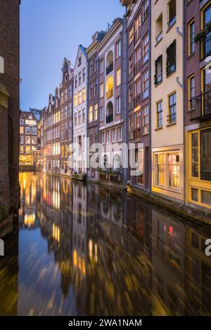 Bunte Gebäude entlang des Kanals in Amsterdam bei Nacht Stockfoto