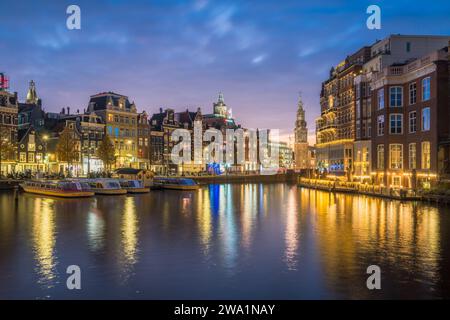 Abendliche Uferpromenade von Amsterdam mit Stadtlichtern Stockfoto