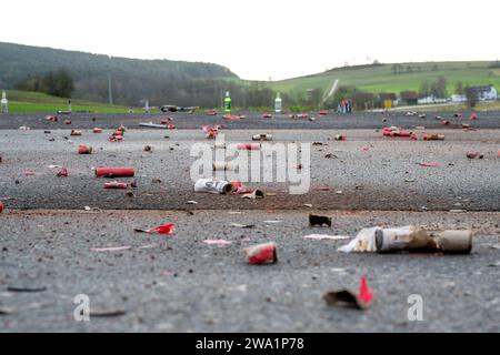 Poppendorf, Deutschland. Januar 2024. Überreste der Partei: Ausgebrannte Feuerwerkskörper und Raketen aus dem letzten Silvester liegen auf einer Straße in Poppendorf in Oberfranken (Bezirk Bamberg). In der Nacht vom 31. Dezember 2023 auf den 1. Januar 2024 wurde das neue Jahr wieder mit Feuerwerk an vielen Orten gefeiert. Quelle: Pia Bayer/dpa/Alamy Live News Stockfoto