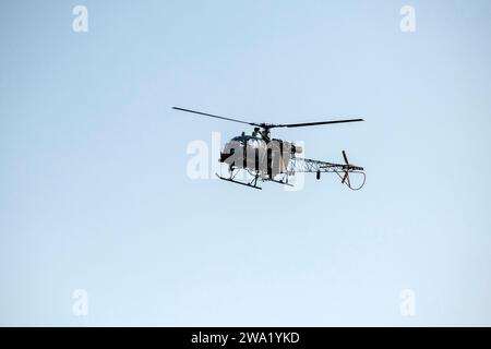 Der Silhouette-Hubschrauber fliegt isoliert am unscharfen Himmel Stockfoto