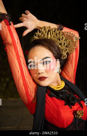 Eine balinesische Frau trägt schweres Make-up mit rosa roten Lippen und scharfem Haar, wenn sie nachts posiert Stockfoto