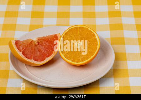 In Scheiben geschnittene Orange und Grapefruit auf Teller. Bio-Obst, gesunde Ernährung und Ernährungskonzept. Stockfoto