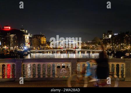 Nächtlicher Blick auf Amsterdam mit der Magere Brug, Carré-Theater, mit Bewegungsunschärfe im Vordergrund Stockfoto