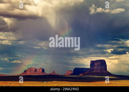 Dunkler Himmel und ein Regenbogen über dem Monument Valley Stockfoto