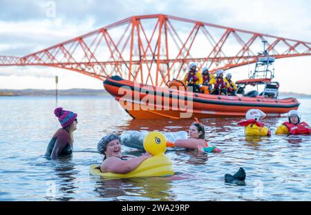 Im Rahmen der Hogmanay-Feierlichkeiten in Edinburgh nehmen die Besucher am Loony Dook Neujahrstag im Firth of Forth in South Queensferry Teil. Bilddatum: Montag, 1. Januar 2024. Stockfoto