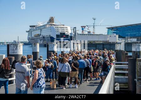 Hafen Kiel Anlegestelle der Personenfähren der Kieler Fördeschiffahrt, Passagiere erwarten das Ankommen der planmäßgen Fähre im Hintergrund die Norwegenfähre *** Hafen Kiel Anlegestelle für die Passagierfähren der Kieler Fördeschiffahrt warten die Passagiere auf die Ankunft der Linienfähre im Hintergrund die Norwegerfähre Stockfoto