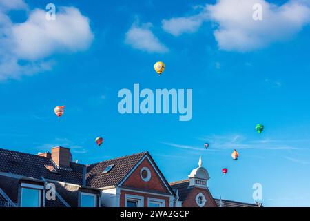 Bunte Heißluftballons über den Dächern der Kieler Altstadt vor blauem Himmel im Sommer Stockfoto