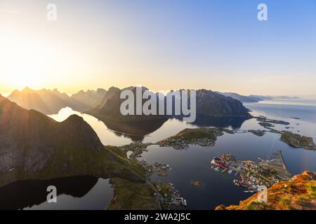 Die Mitternachtssonne taucht sanft in Richtung Horizont, ein atemberaubender Blick von Reinebringen mit scharfen Bergkämmen und Meer. Norwegen Stockfoto