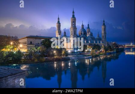 Panoramablick auf die Basilika unserer Lieben Frau von der Säule und den Fluss Ebro von der Steinbrücke in Saragossa bei sunsert Stockfoto