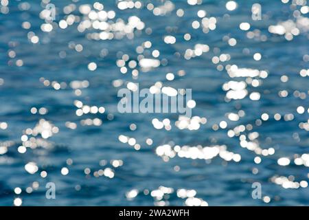 Unscharfe Lichter oder Bokeh-Effekt vor blauem Wasser als Hintergrund Stockfoto