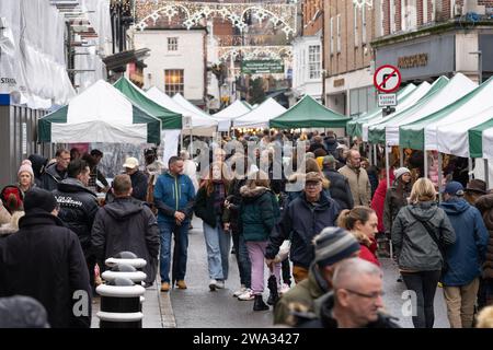 Besucher des Weihnachtsmarktes in Winchester High Street stöbern und an verschiedenen Verkaufsständen Geschenke und Geschenke kaufen. Winchester, Großbritannien Stockfoto