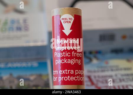 Kunststofffreie Verpackung für eine Rolle Tesco Weihnachtspapier mit Weihnachtsgeschenken dahinter. UK. Thema: Abfallreduzierung, Kunststoffreduzierung Stockfoto