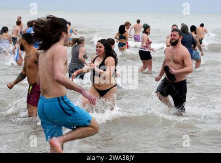 Racine, Wisconsin, USA. Januar 2024. Badende laufen am Noon New YearÃs Day in Racine, Wisconsin, zum 35. Jährlichen Splash and Dash Polar Plunge in den Lake Michigan. Die Lufttemperatur betrug 30 Grad, aber der windchill war 20 Grad und die Wassertemperatur 42 Grad. Das gesammelte Geld wird an drei Wohltätigkeitsorganisationen verteilt. Eine Bar hat $11.000. Quelle: ZUMA Press, Inc./Alamy Live News Stockfoto