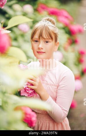 Porträt einer entzückenden Ballerina, die im Garten der Hortensie spielt, Tutu-Kleid und Prinzessinnenkrone trägt Stockfoto