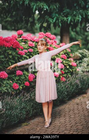 Ein kleines Ballerina-Mädchen, das im Hortensie-Garten tanzt, im Tutu-Kleid Stockfoto