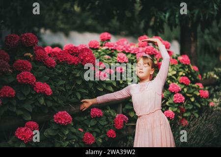 Ein kleines Ballerina-Mädchen, das im Hortensie-Garten tanzt, im Tutu-Kleid Stockfoto