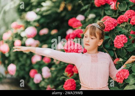 Ein kleines Ballerina-Mädchen, das im Hortensie-Garten tanzt, im Tutu-Kleid Stockfoto