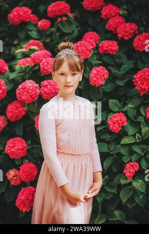 Ein kleines Ballerina-Mädchen, das im Hortensie-Garten tanzt, im Tutu-Kleid Stockfoto