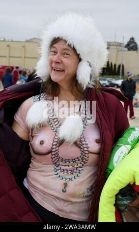 Racine, Wisconsin, USA. Januar 2024. MOLLY CROSS zeigt ihr „freches T-Shirt“, das ihr Sohn von einer Reise nach New Orleans mitbrachte, bevor sie und andere Badende am Mittag des Neujahrstages in Racine, Wisconsin, zum 35. Jährlichen Splash and Dash Polar Plunge in den Lake Michigan fahren. Die Lufttemperatur betrug 30 Grad, aber der windchill war 20 Grad und die Wassertemperatur 42 Grad. Das gesammelte Geld wird an drei Wohltätigkeitsorganisationen verteilt. Eine Bar hat $11.000. Quelle: ZUMA Press, Inc./Alamy Live News Stockfoto