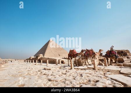 Gizeh, Ägypten - 24. Dezember 2023: Die große Pyramide Khufu (Cheops-Pyramide) ist die älteste und größte der drei Pyramiden in Gizeh und Kamelen Stockfoto