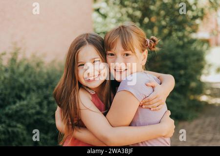 Sommerporträt zweier entzückender Mädchen, die sich umarmen Stockfoto
