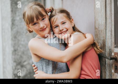 Sommerporträt zweier entzückender Mädchen, die sich umarmen Stockfoto