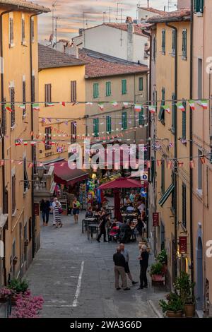 Erhöhter Blick auf die Hauptstraße von Castagneto Carducci mit Menschen im Sommer bei Sonnenuntergang, Livorno, Toskana, Italien Stockfoto