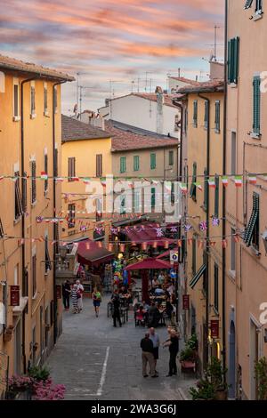 Erhöhter Blick auf die Hauptstraße von Castagneto Carducci mit Menschen im Sommer bei Sonnenuntergang, Livorno, Toskana, Italien Stockfoto