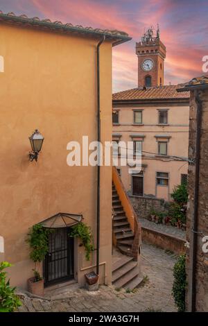 Erhöhter Blick auf das mittelalterliche Dorf in der toskanischen Maremma mit dem Bürgerturm gegen Sonnenuntergang im Sommer, Castagneto Carducci, Livorno, Toskana Stockfoto