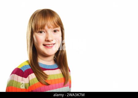 Studio-Aufnahme eines jungen, 9-10-jährigen Mädchens mit buntem Pullover, weißem Hintergrund Stockfoto