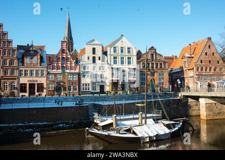 Bunte Häuserfassaden, Giebelhäuser, alter Hafen an der Straße am Stintmarkt, im Wasser zwei schneebedeckte historische Segelboote oder Segelschiffe Stockfoto