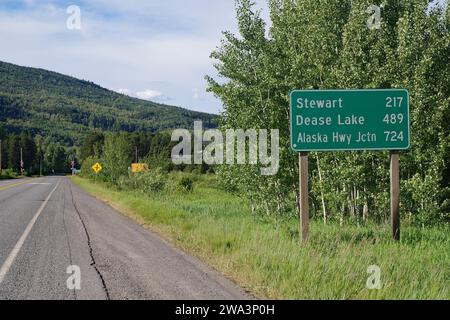 Schmale, verkehrsfreie Straße führt durch Waldlandschaft, Schild mit riesigen Entfernungen, Wildnis, Stewart Cassiar Highway, British Columbia, Kanada, Noch Nicht Stockfoto