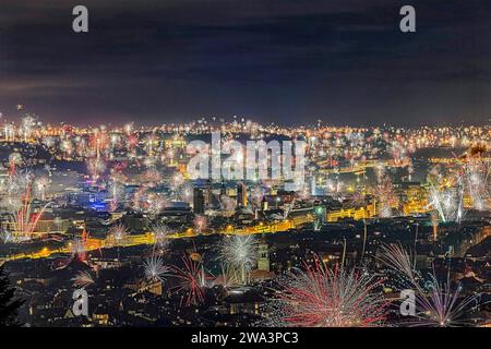 Stuttgart begrüßt das neue Jahr 2024 mit einem Feuerwerk über der Innenstadt. In der Bildmitte: Rathausturm, Stiftskirche und Old PAL Stockfoto