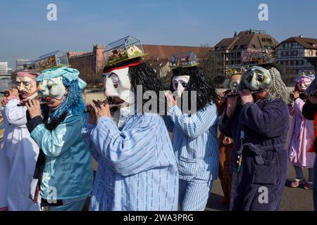 Fasnächtler mit kreativem Kopfschmuck in Form eines Gewächshauses auf der Mittleren Brücke vor dem Cortege der Basler Fasnacht in Basel, Kanton Basel- Stockfoto