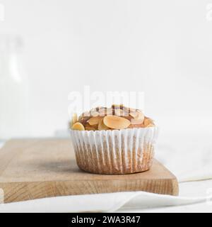 Vanillemandelmuffins auf einem Schneidebrett, hausgemachte Mandelmuffins im Bäckereistil auf weißem Hintergrund Stockfoto