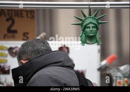 New York, USA. Januar 2024. Eine Nachbildung des Kopfes der Freiheitsstatue hängt an einem Verkaufstisch am Eingang der Brooklyn Bridge Manhattan Side Promenade, New York, NY, 1. Januar 2024. New York City wird ab dem 3. Januar 2024 den Händlern die Errichtung der Brooklyn Bridge (und aller anderen Brücken) verbieten, um Fußgängerwege und Touristen durch die Verringerung der Menschenmassen sicherer zu machen. (Foto: Anthony Behar/SIPA USA) Credit: SIPA USA/Alamy Live News Stockfoto