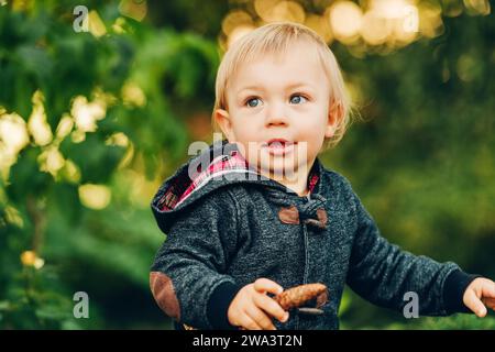 Ein entzückender 1-jähriger Junge, der an einem schönen sonnigen Tag im Park spielt Stockfoto