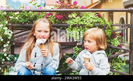 Gruppe von zwei Kindern, kleiner Junge und Mädchen, die draußen Eis essen, Foto aufgenommen in Annecy, Frankreich Stockfoto