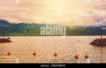 Sonnenuntergang über dem Genfer See (Lac Leman), Blick auf die kleine französische Stadt Evian in Haute-Savoie, Auvergne-Rhone-Alpes Region. Bild aufgenommen in Lausanne, Schweiz Stockfoto