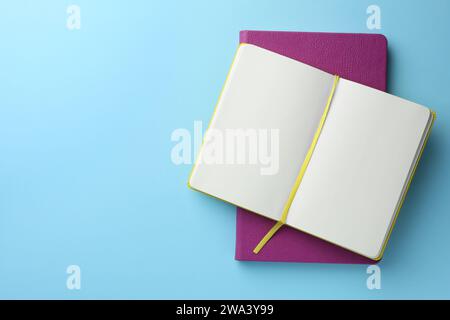 Verschiedene Notizbücher auf hellblauem Hintergrund, Draufsicht. Leerzeichen für Text Stockfoto