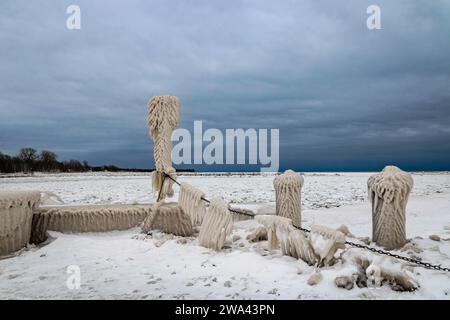 Seltsame Eisformationen am Pier in Lake Erie, Kanada, Tag nach Wintersturm, stürmischer Himmel Stockfoto